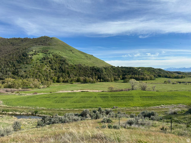 4250 East Cub River Road Preston, ID 83263 - Photo 3 of 18 Expansive open land featuring rolling green hills, a small stream, and distant mountains
