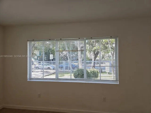 a view of a room that has a large window and bed