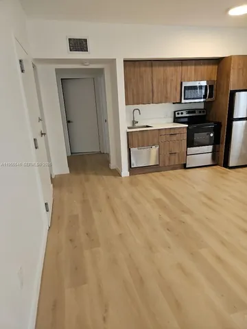 a view of kitchen with refrigerator stove and microwave