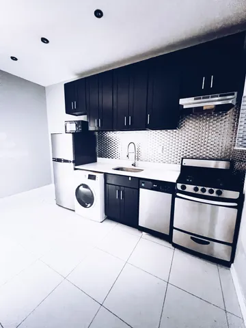 a kitchen with stainless steel appliances kitchen island granite countertop a sink and a stove