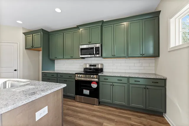 a kitchen with granite countertop cabinets stainless steel appliances and a sink