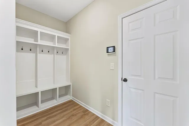 a view of an empty room with wooden floor and closet