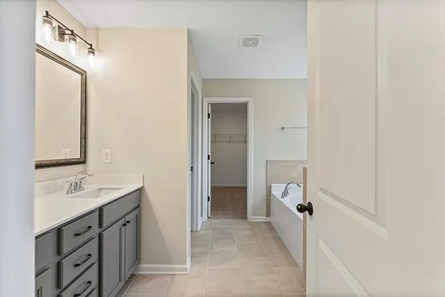a spacious bathroom with a double vanity sink a mirror and a