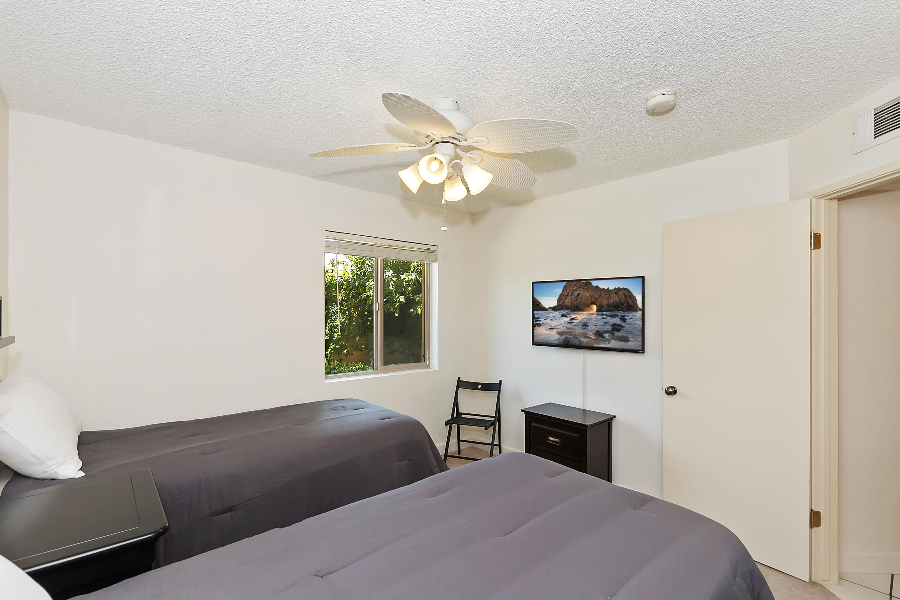 48255 Monroe Street, Unit 6 Indio, CA 92201 - Photo 14 of 43 a bedroom with a bed and a chandelier
