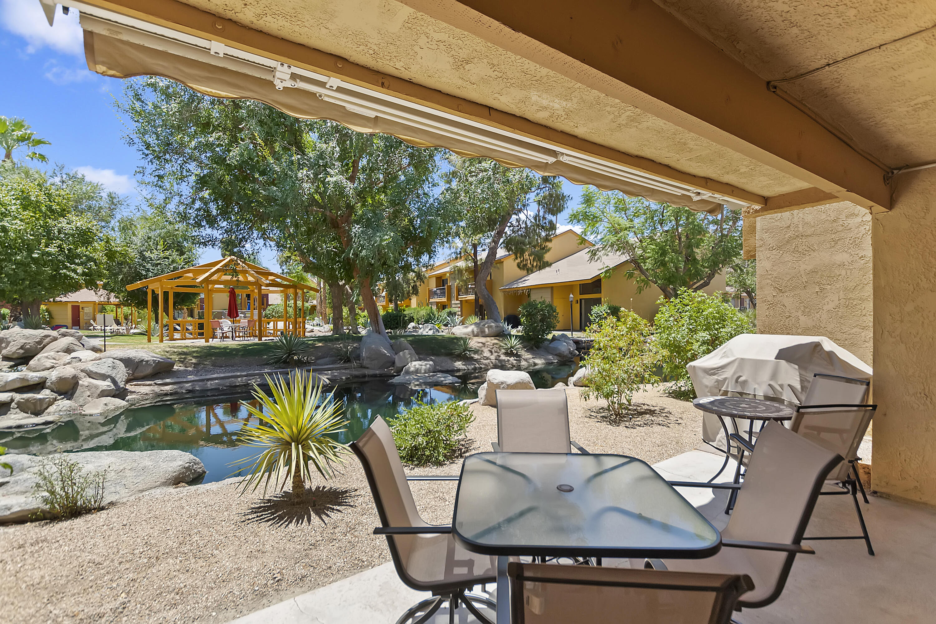 48255 Monroe Street, Unit 6 Indio, CA 92201 - Photo 17 of 43 a view of a patio with table and chairs and potted plants