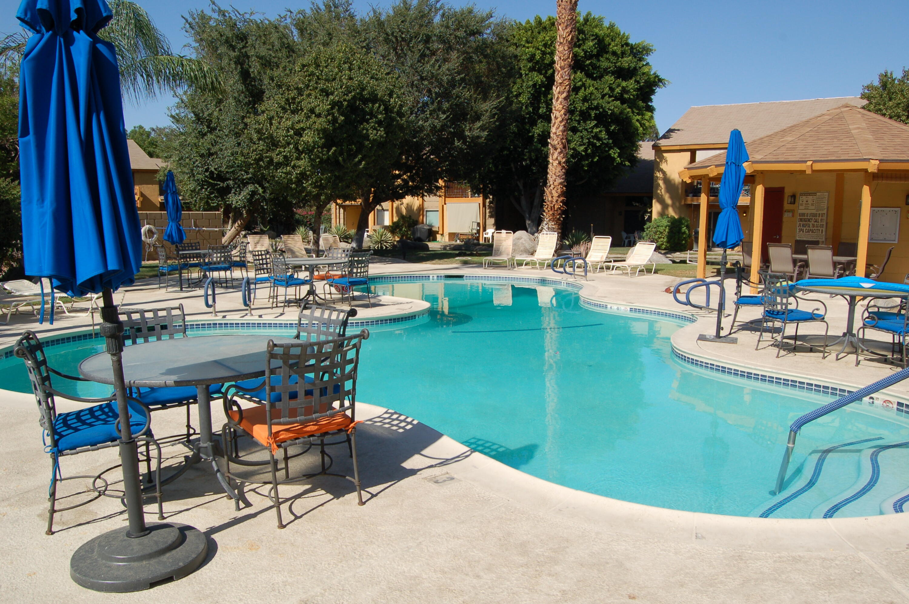 48255 Monroe Street, Unit 6 Indio, CA 92201 - Photo 38 of 43 a view of a swimming pool with chairs and table in patio