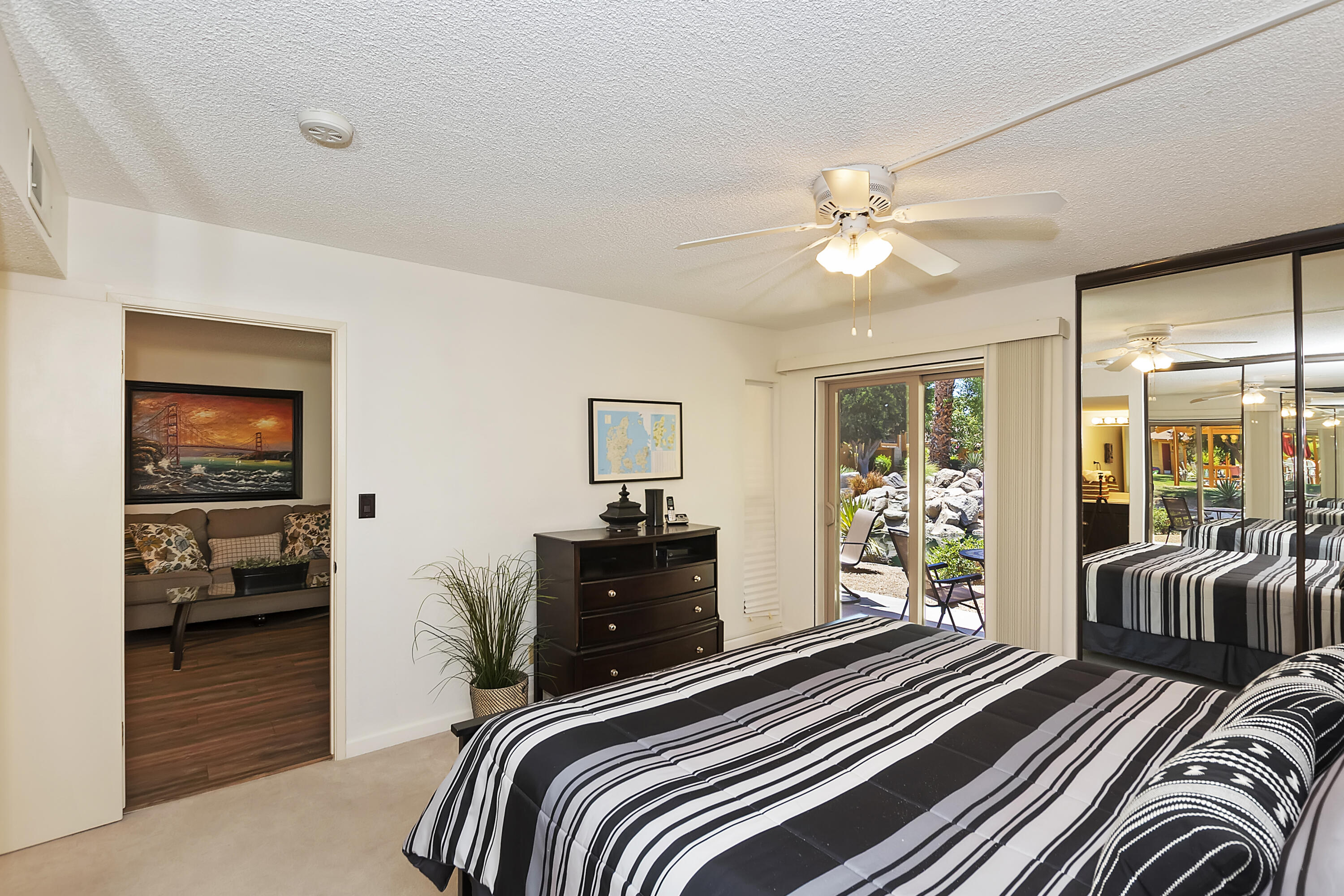48255 Monroe Street, Unit 6 Indio, CA 92201 - Photo 10 of 43 a bedroom with a bed and a chandelier
