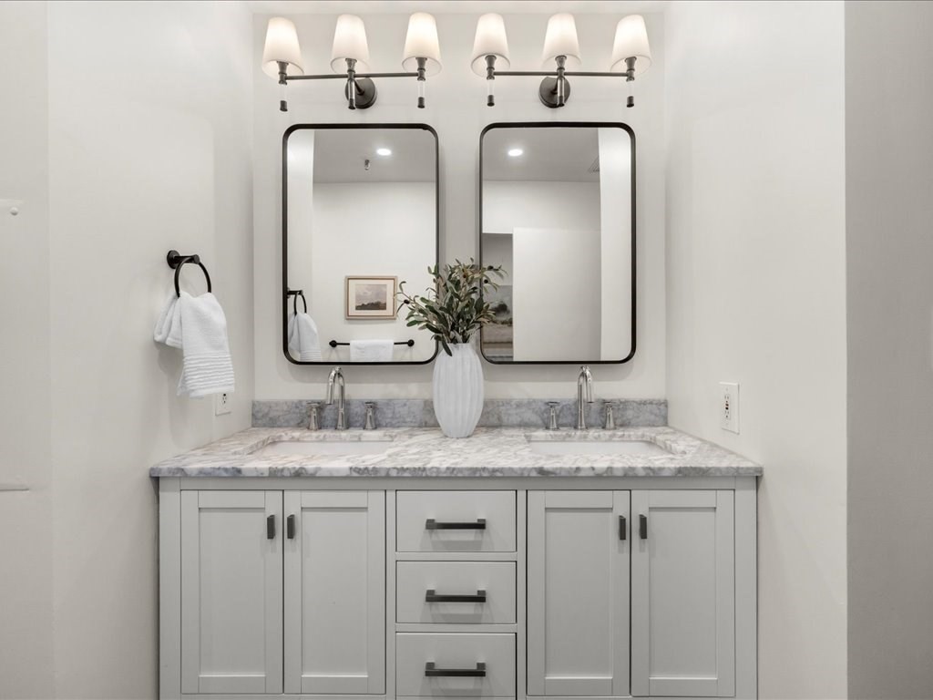 33 Sleeper Street, Unit 104 Boston, MA 02210 - Photo 13 of 23 a bathroom with a granite countertop sink and a mirror