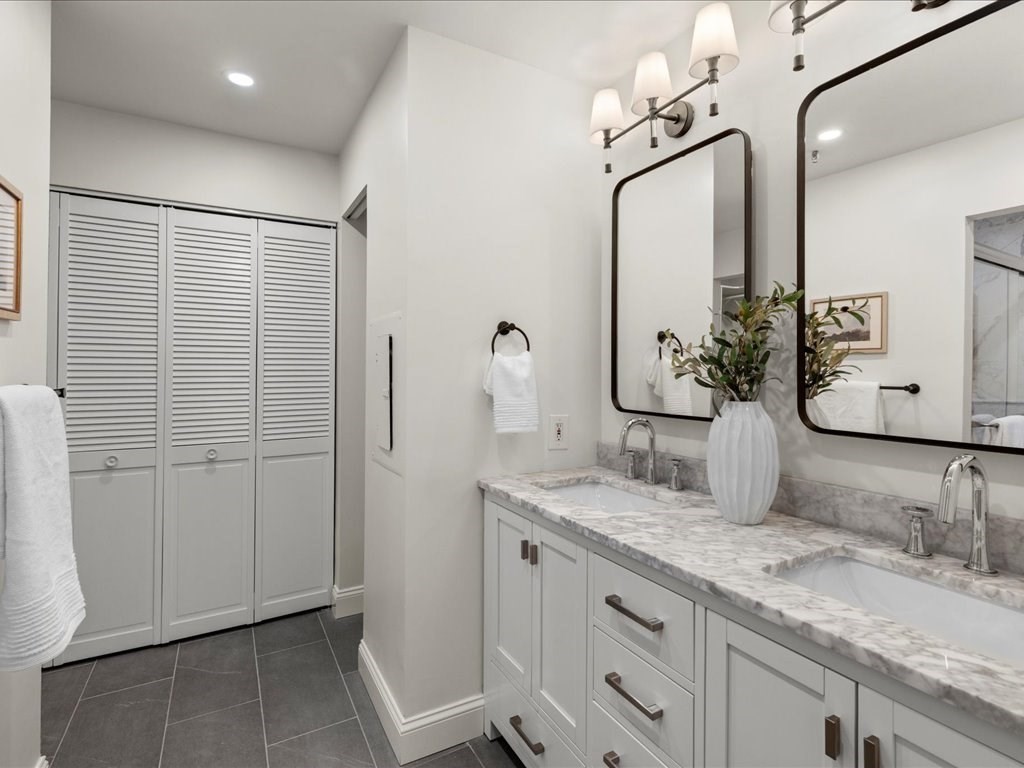 33 Sleeper Street, Unit 104 Boston, MA 02210 - Photo 14 of 23 a bathroom with a granite countertop sink vanity and mirror