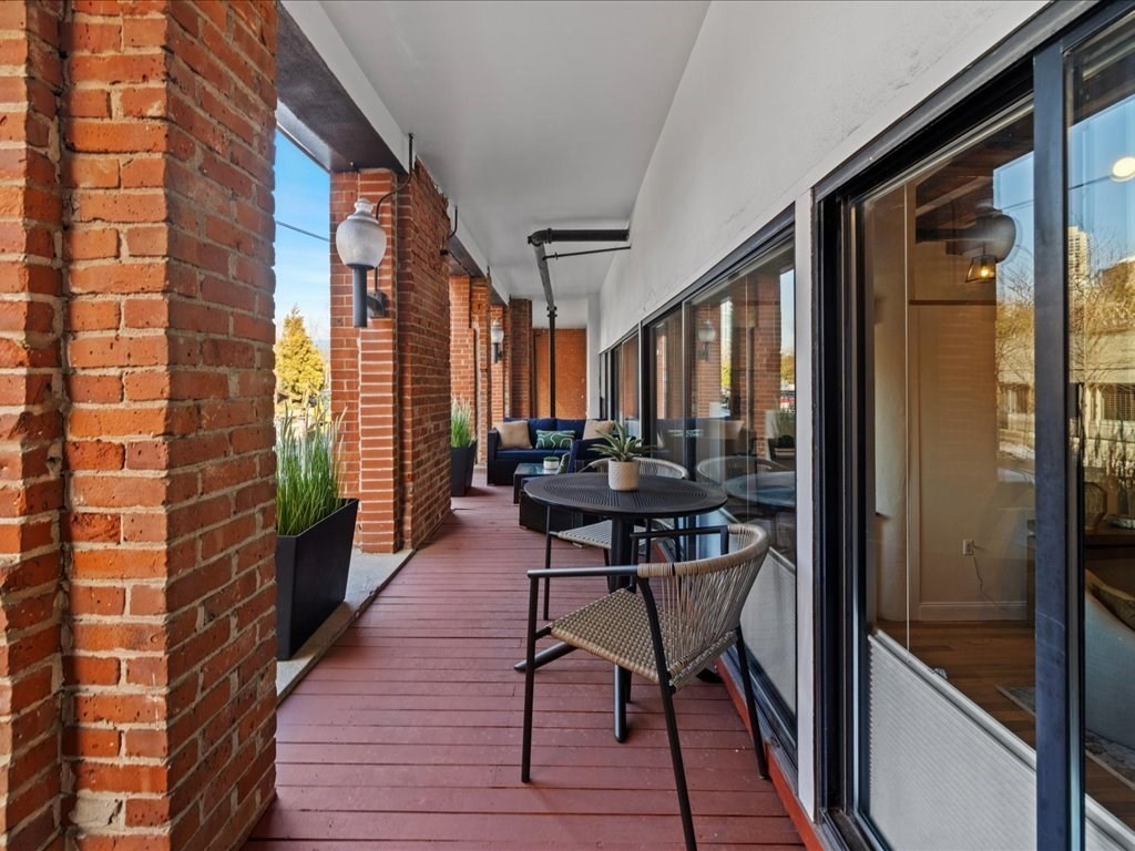 33 Sleeper Street, Unit 104 Boston, MA 02210 - Photo 18 of 23 a balcony filled with furniture and wooden floor