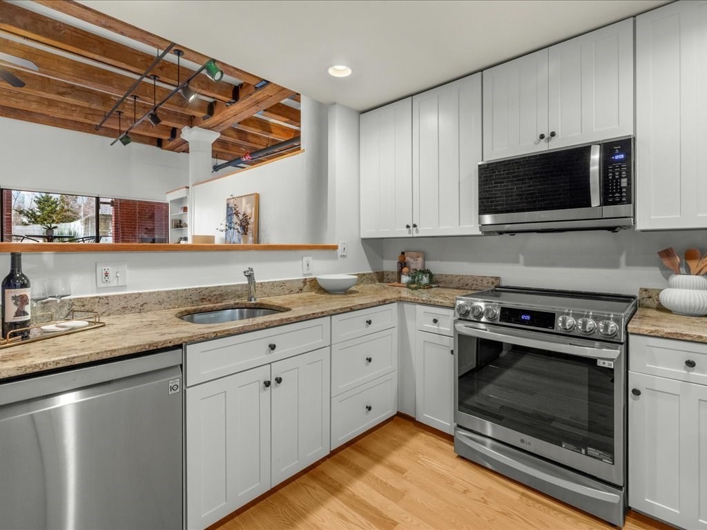 33 Sleeper Street, Unit 104 Boston, MA 02210 - Photo 8 of 23 a kitchen with granite countertop a stove sink and microwave