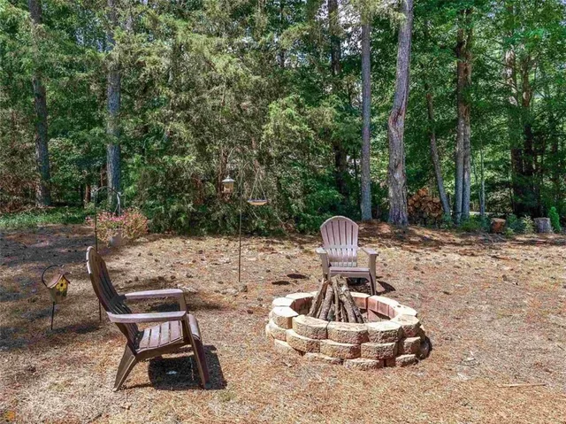 a view of a chairs and fire pit in the backyard