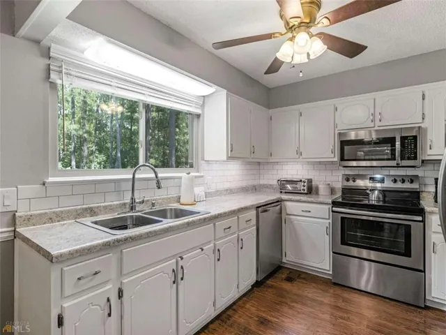 a kitchen with a sink appliances and cabinets