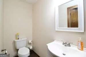 a bathroom with a sink a toilet and mirror