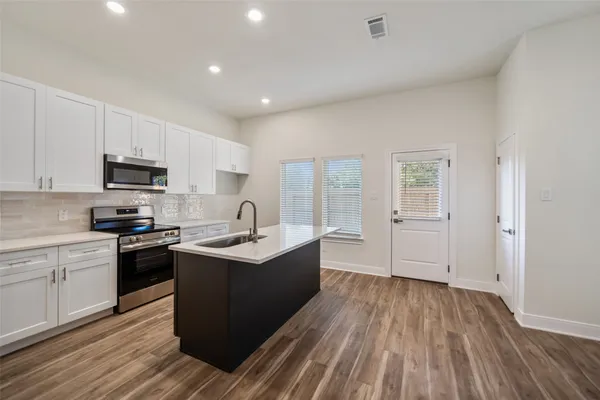 a kitchen with a sink window and cabinets