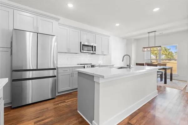 a kitchen with kitchen island white cabinets and stainless steel appliances