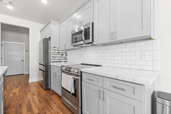 a kitchen with stainless steel appliances granite countertop a stove a refrigerator and a microwave