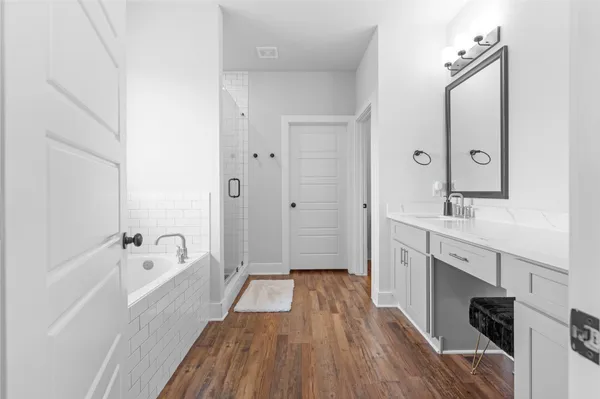 a bathroom with a sink a mirror a bathtub and shower