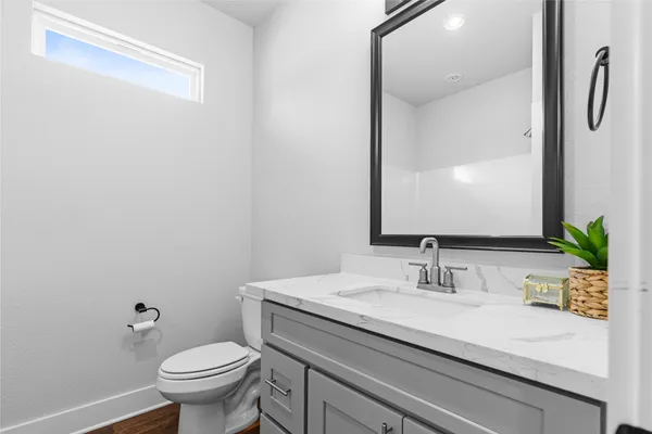 a bathroom with a sink a toilet and a mirror