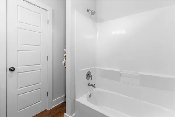 a white bath tub sitting next to a shower