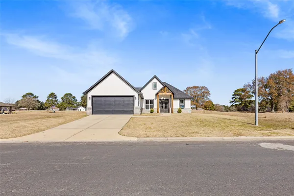 a view of road and house with wooden fence