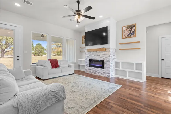 a living room with furniture a flat screen tv and a fireplace