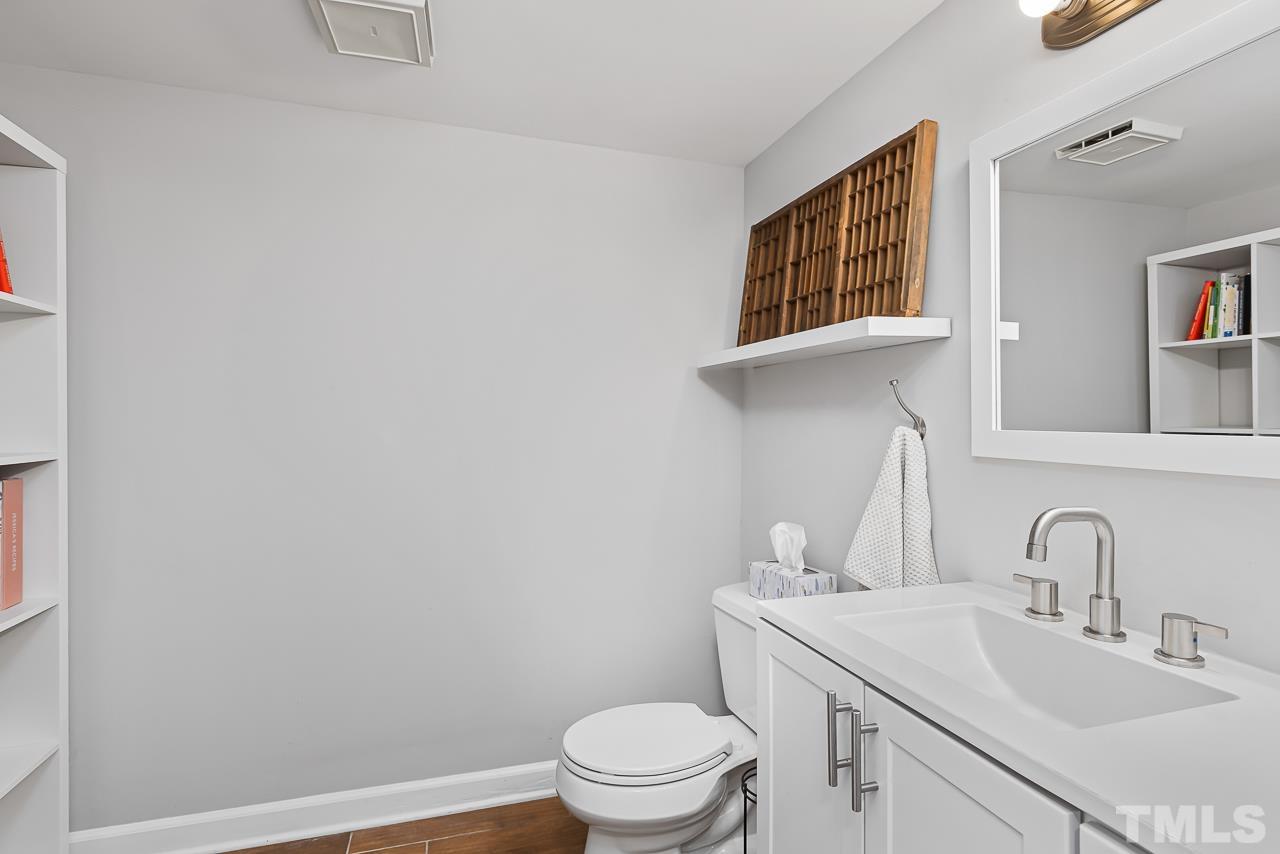 7929 Kingsland Drive Raleigh, NC 27613 - Photo 31 of 46 a bathroom with a sink a toilet and a mirror