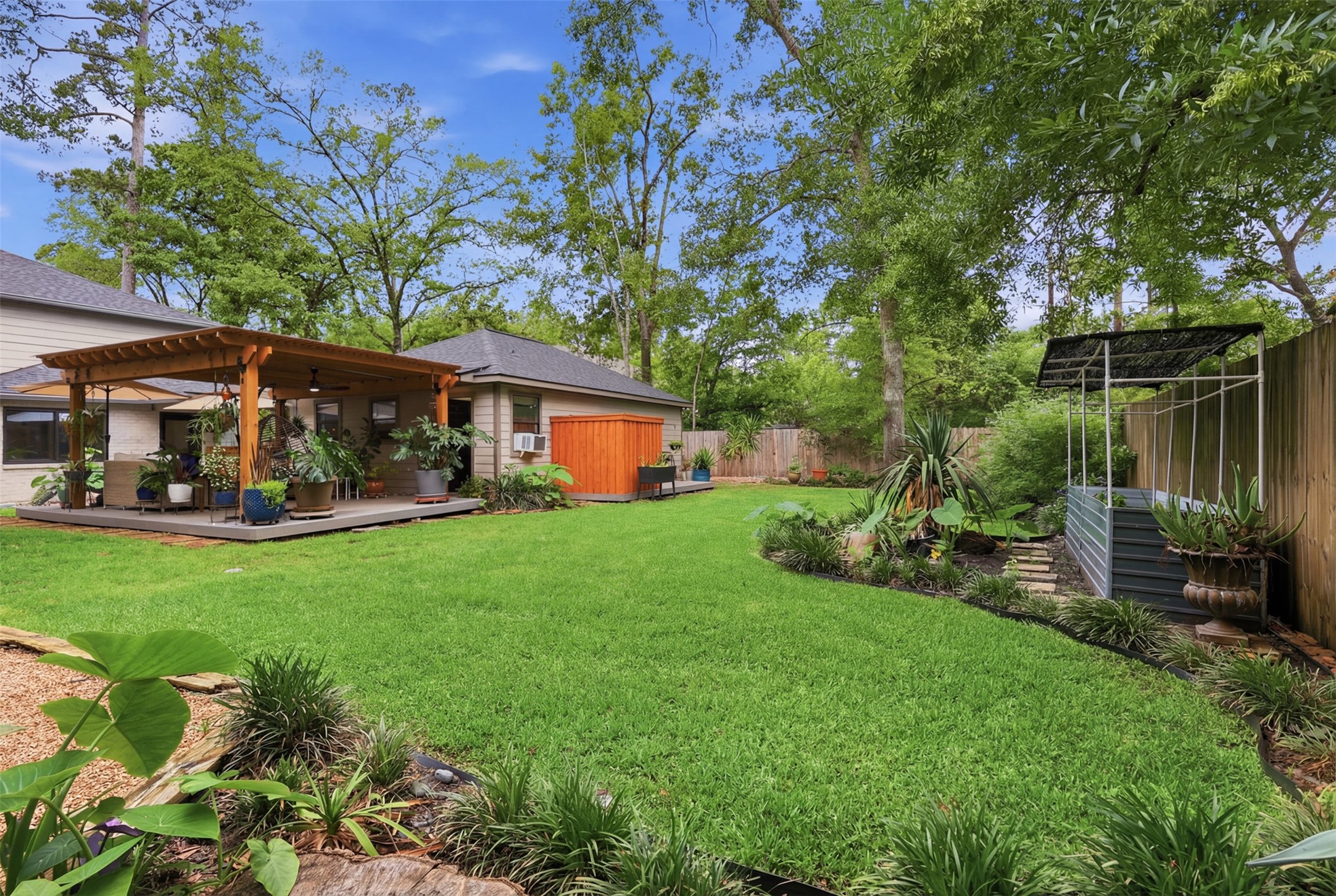 6126 Hickorycrest Drive Spring, TX 77389 - Photo 40 of 50 Another backyard angle featuring mature trees, garden beds, and plenty of open space.