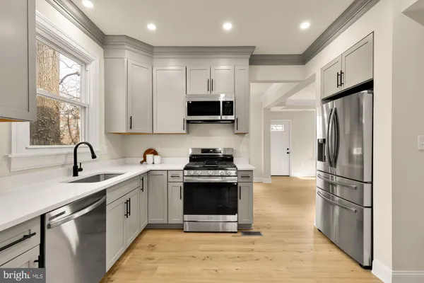 a kitchen with stainless steel appliances granite countertop a stove a sink and a refrigerator