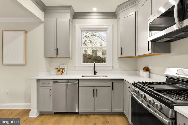 a kitchen with a sink stove and cabinets