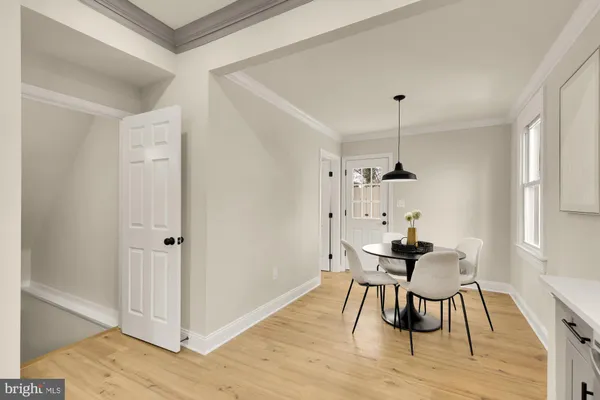 a view of a room with wooden floor table and chairs
