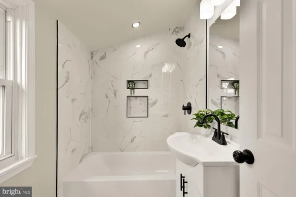a bathroom with a bathtub shower and a sink