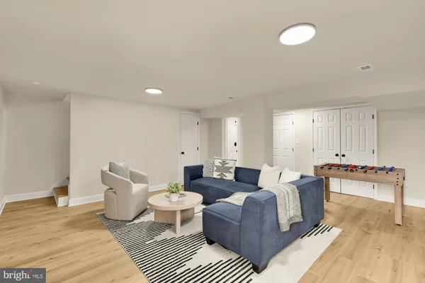 a living room with furniture and a wooden floor