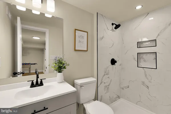 a bathroom with a sink vanity mirror and toilet