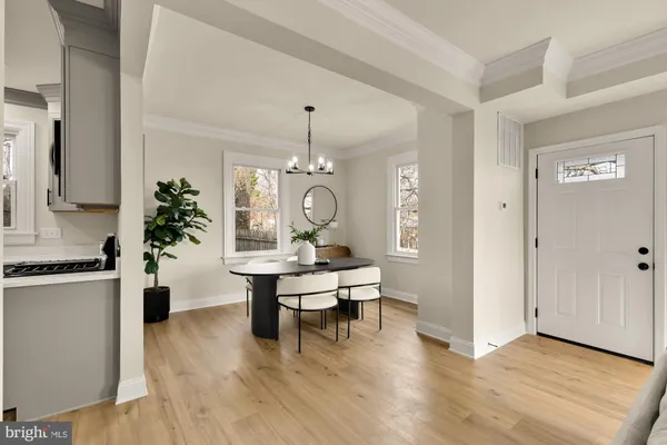 a living room with furniture a chandelier and wooden floor