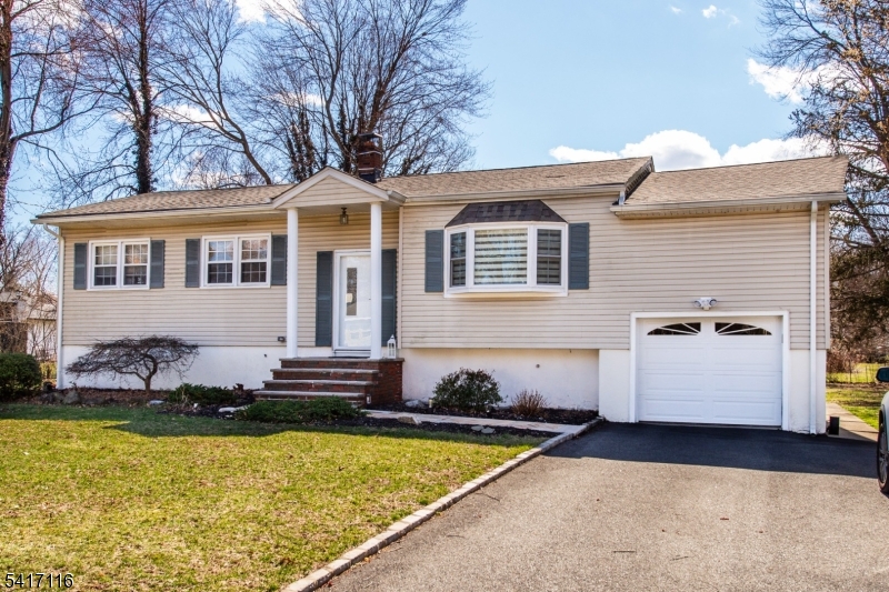a front view of a house with a yard and swimming pool