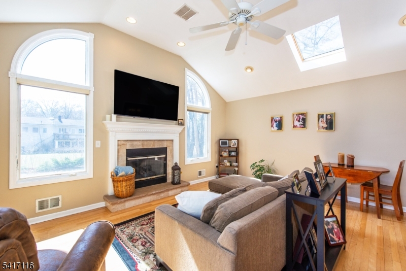 29 Long Acres Road Fairfield, NJ 07004 - Photo 8 of 33 a living room with furniture a flat screen tv and a fireplace