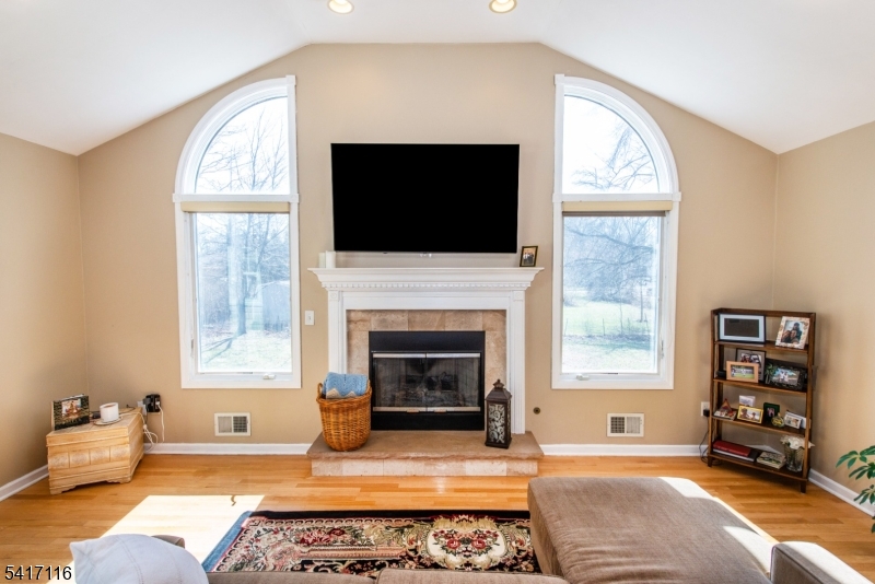 29 Long Acres Road Fairfield, NJ 07004 - Photo 9 of 33 a living room with furniture a flat screen tv and a fireplace