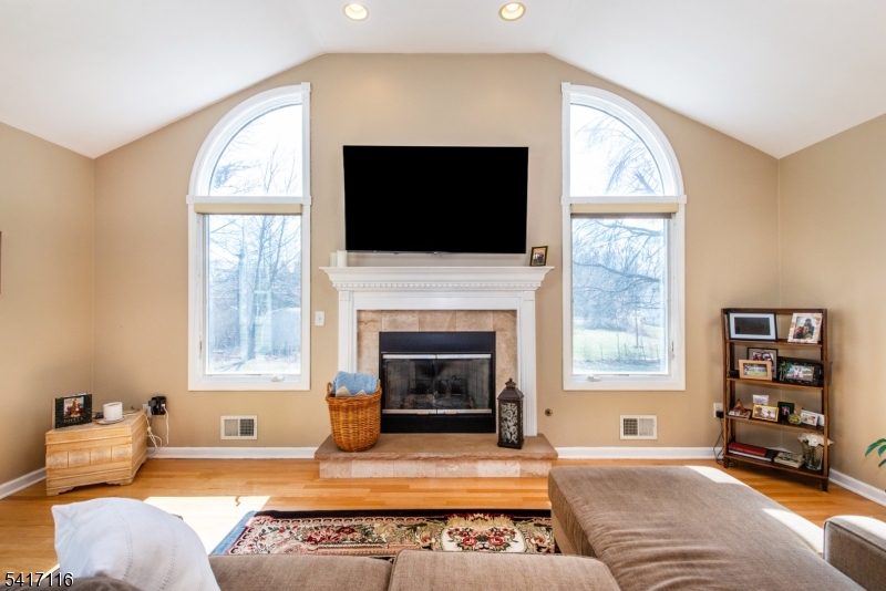 29 Long Acres Road Fairfield, NJ 07004 - Photo 10 of 33 a living room with furniture a flat screen tv and a fireplace