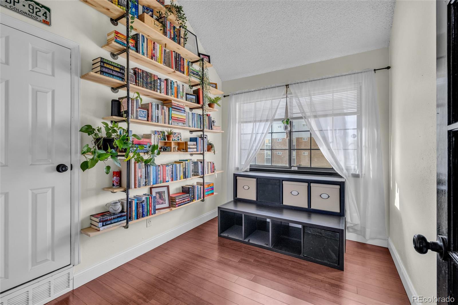 4840 East Kentucky Avenue, Unit F Denver, CO 80246 - Photo 14 of 18 a living room with furniture and a book shelf