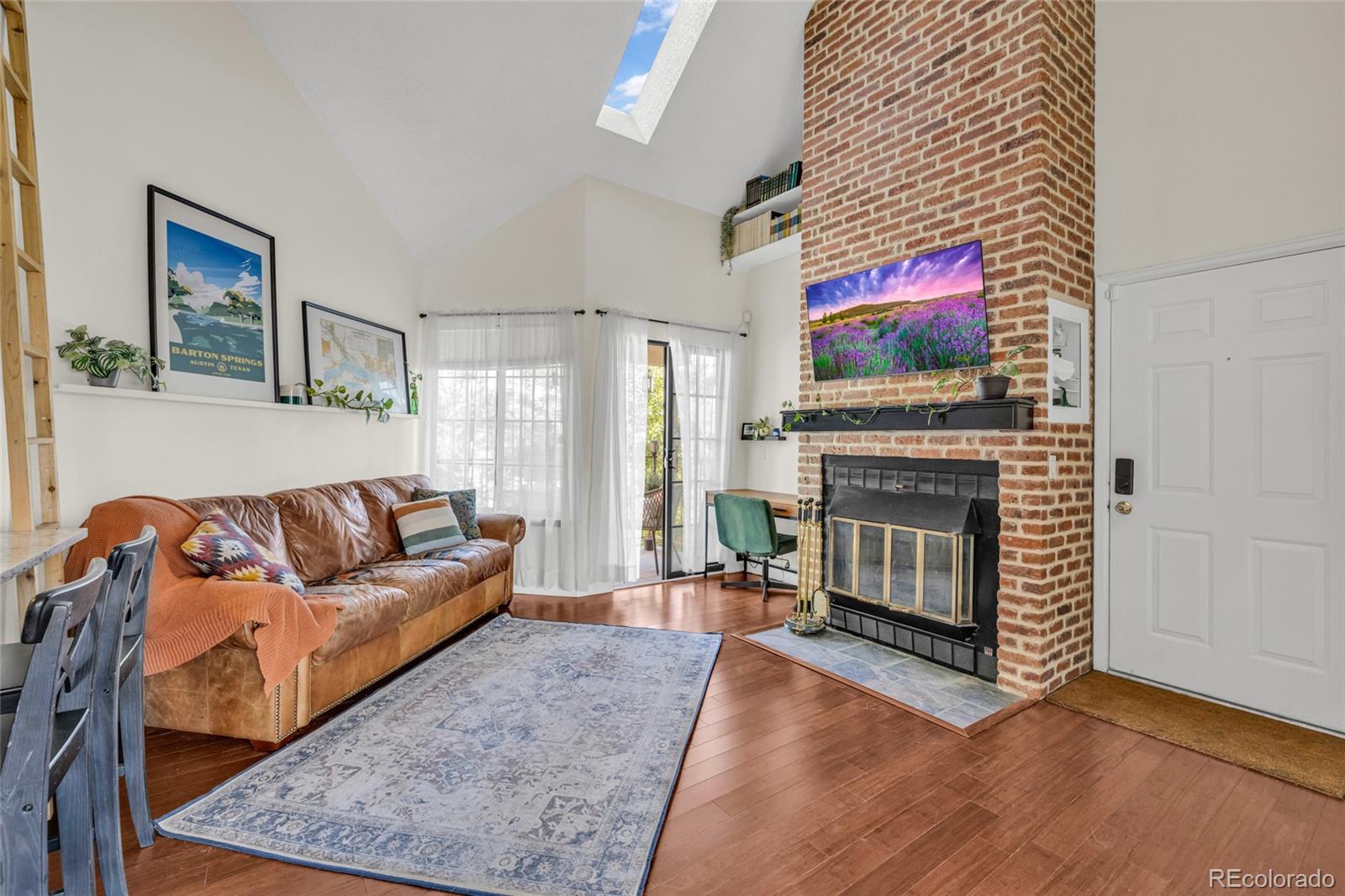 4840 East Kentucky Avenue, Unit F Denver, CO 80246 - Photo 4 of 18 a living room with furniture a flat screen tv and a fireplace