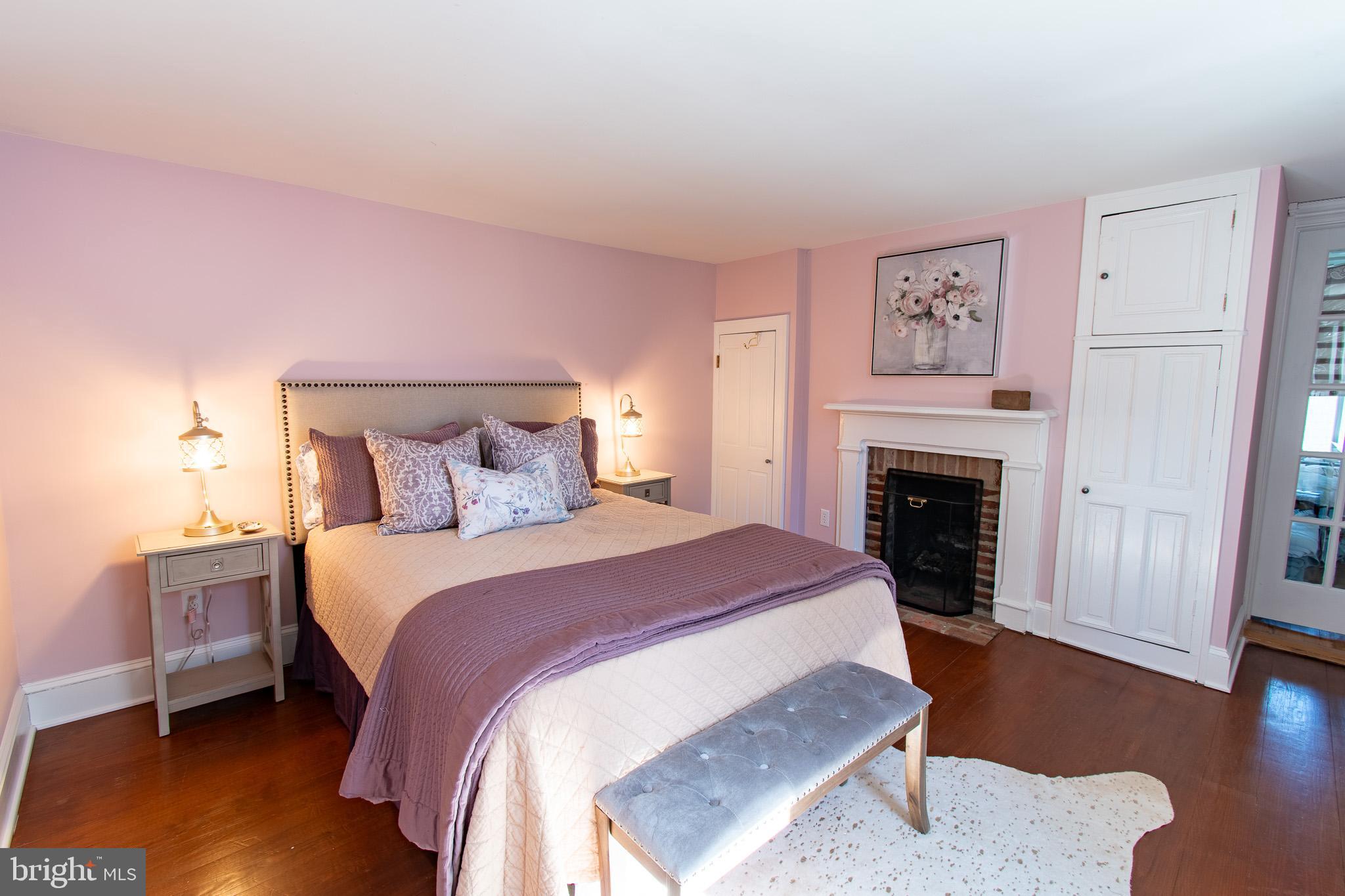 114 West Chestnut Street St. Michaels, MD 21663 - Photo 26 of 75 a spacious bedroom with a bed and a fireplace