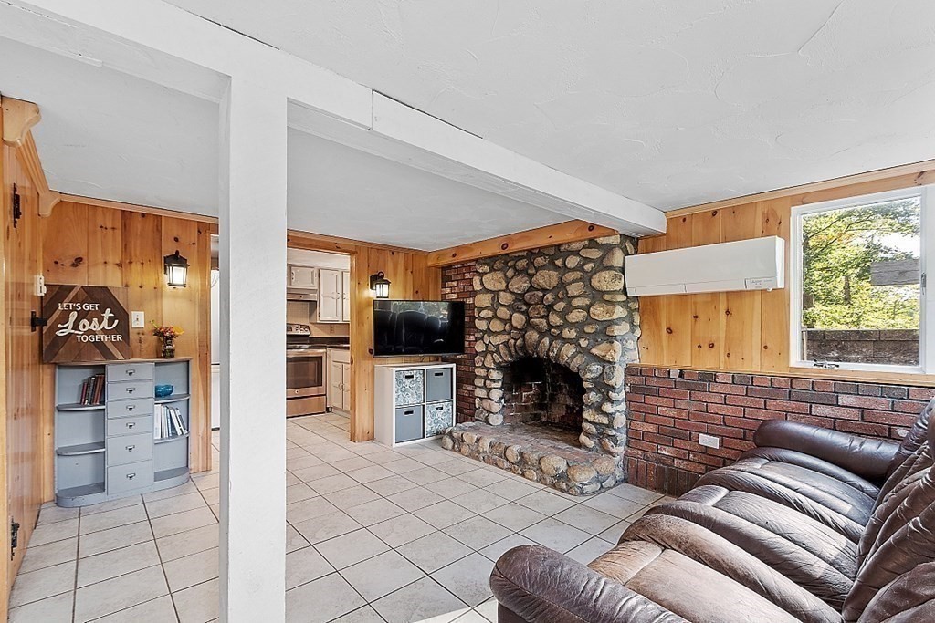 98 Boat House Road Groton, MA 01450 - Photo 32 of 39 a living room with furniture a fireplace and a flat screen tv