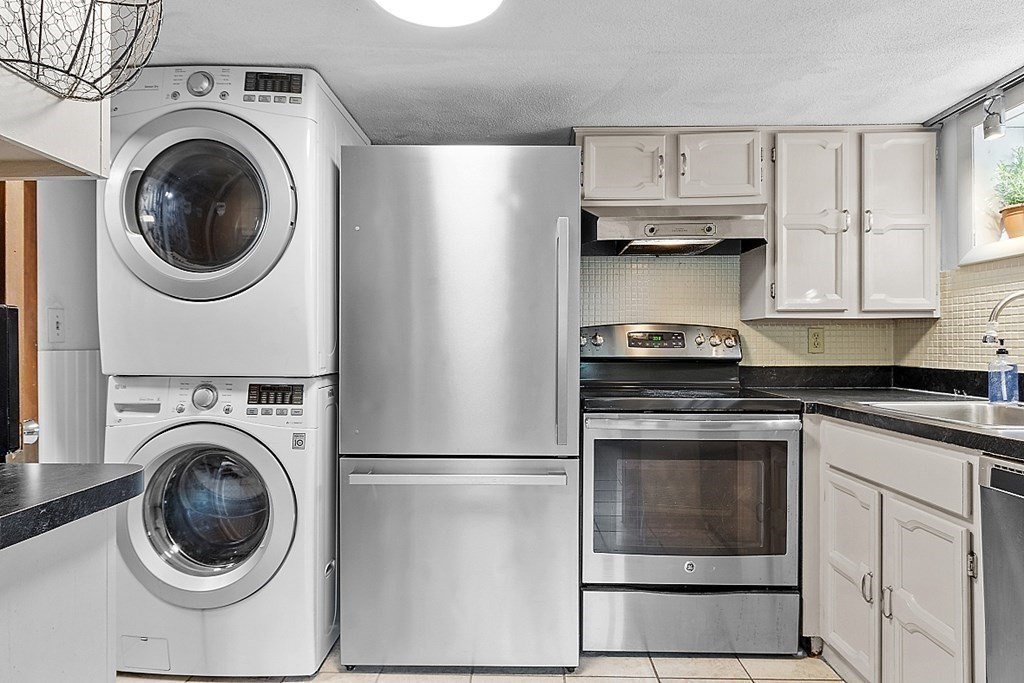 98 Boat House Road Groton, MA 01450 - Photo 35 of 39 a kitchen with stainless steel appliances cabinets and a washer dryer