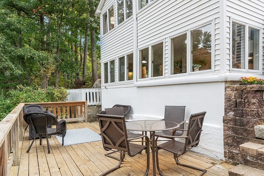 98 Boat House Road Groton, MA 01450 - Photo 9 of 39 a view of a patio with table and chairs and wooden floor