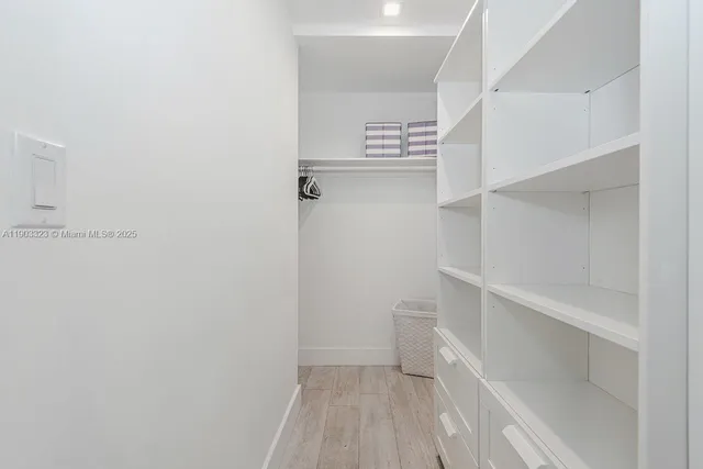 a view of walk in closet with empty racks