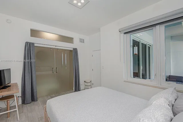 a bedroom with a bed and a flat screen tv