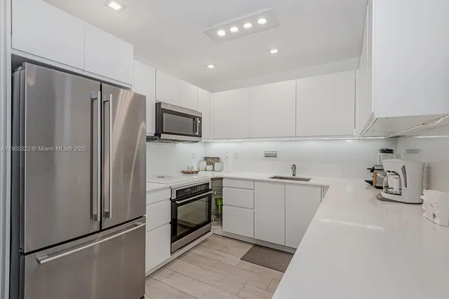 a kitchen with stainless steel appliances a refrigerator sink and microwave