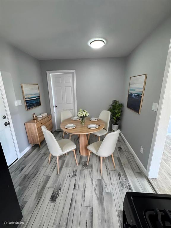 1736 Ransom Terrace Fort Worth, TX 76112 - Photo 6 of 27 Dining area featuring wood-finish flooring, light gray wall paint, and a flush-mount ceiling light