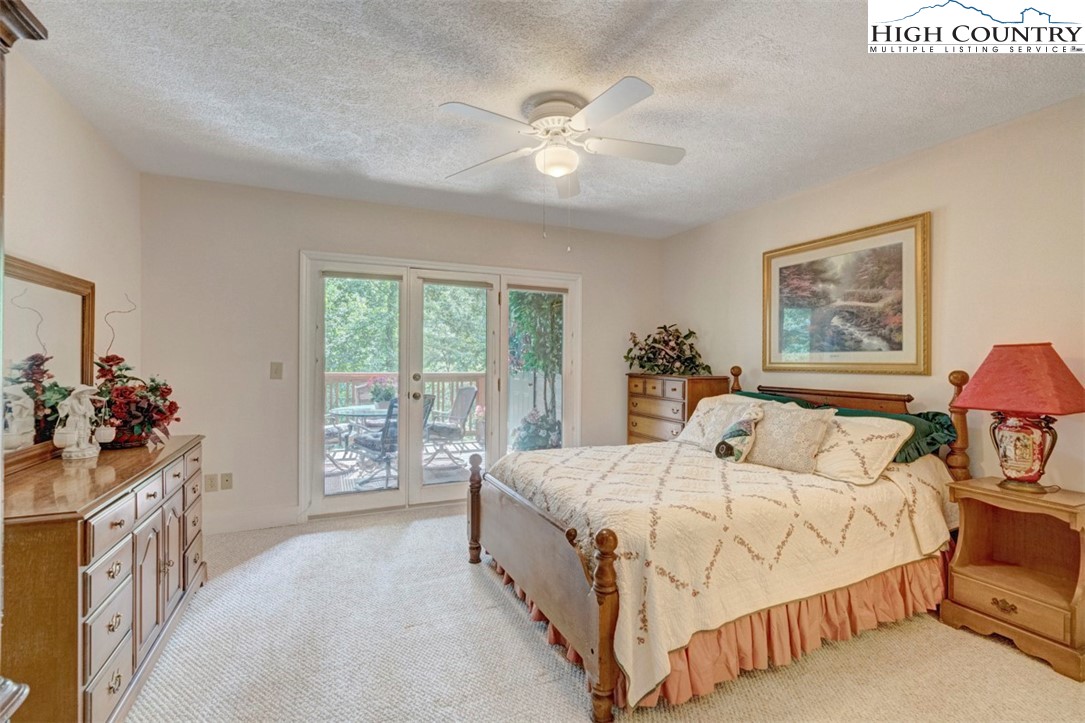 190 Still Lake Drive, Unit 321 Boone, NC 28607 - Photo 12 of 30 a bedroom with a bed a chandelier and a window
